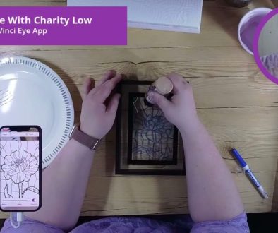 # Description In this Da Vinci Eye App drawing tutorial, the person is tracing or transferring a flower design from a smartphone screen onto paper using a light projection method, with a white paper plate serving as a diffuser for the light source.
