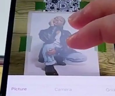 # Screenshot Description The person is using an iPad drawing app to edit or manipulate a digital image of an illustrated character, with their finger positioned on the screen while adjustment options like "Move," "Hide," and "Opacity" are visible at the bottom.